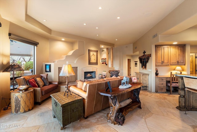 living room featuring recessed lighting, visible vents, and a glass covered fireplace