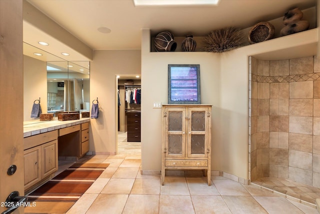 bathroom featuring vanity, baseboards, recessed lighting, a tile shower, and tile patterned flooring