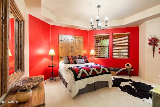 carpeted bedroom featuring a raised ceiling and a notable chandelier