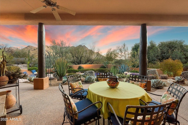 view of patio featuring outdoor dining area, a mountain view, and ceiling fan