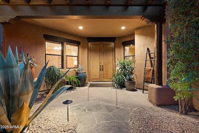 doorway to property featuring stucco siding and a patio