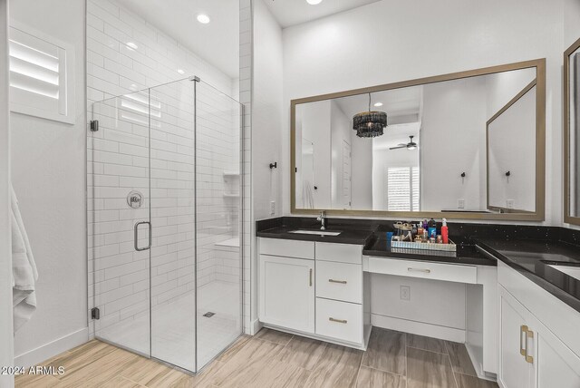 bathroom featuring ceiling fan, walk in shower, and vanity