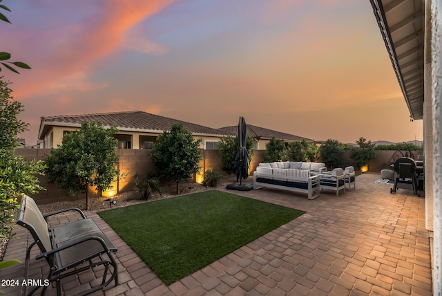 yard at dusk featuring outdoor lounge area and a patio area