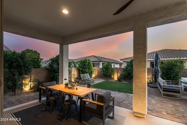 patio terrace at dusk with a lawn and ceiling fan