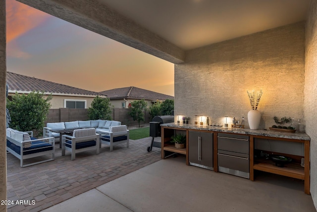 patio terrace at dusk featuring an outdoor hangout area and a grill