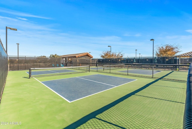 view of tennis court with basketball hoop