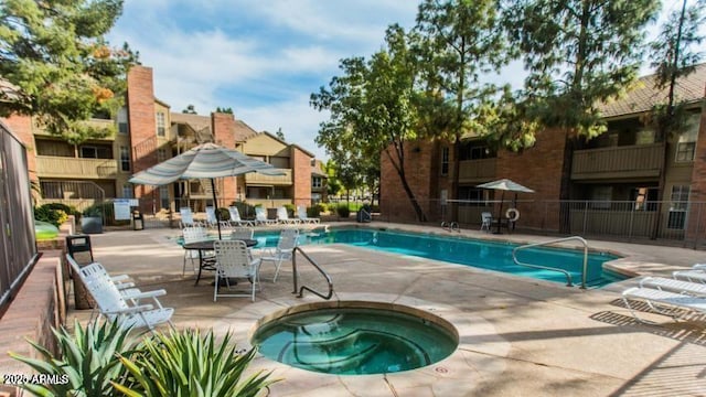 view of swimming pool featuring a community hot tub and a patio