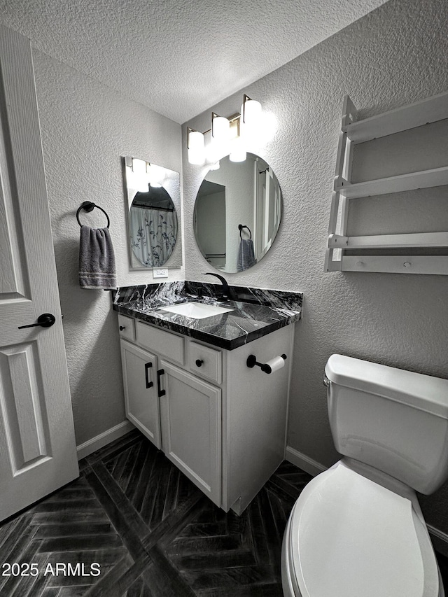 bathroom with vanity, a textured ceiling, and toilet