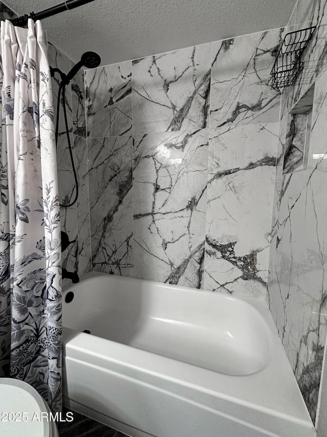 bathroom featuring shower / bathtub combination with curtain and a textured ceiling