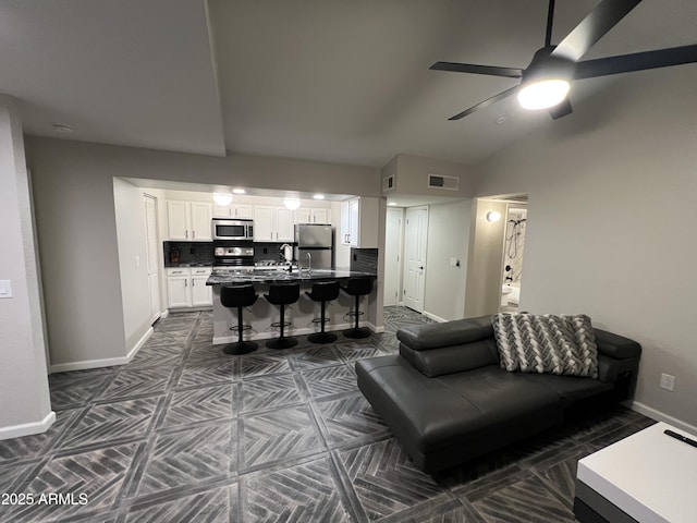 living room featuring vaulted ceiling, sink, and ceiling fan