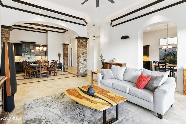 tiled living room with beam ceiling, ceiling fan with notable chandelier, and ornamental molding