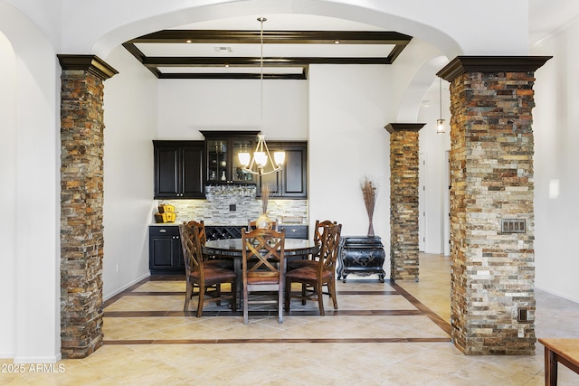 dining area with beamed ceiling, a chandelier, and decorative columns