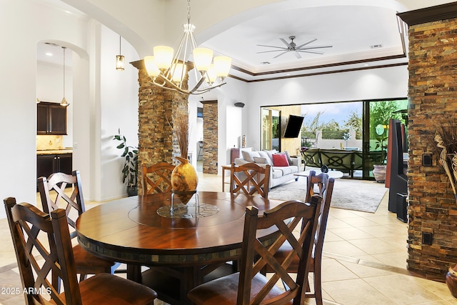 tiled dining space with ceiling fan with notable chandelier and ornamental molding