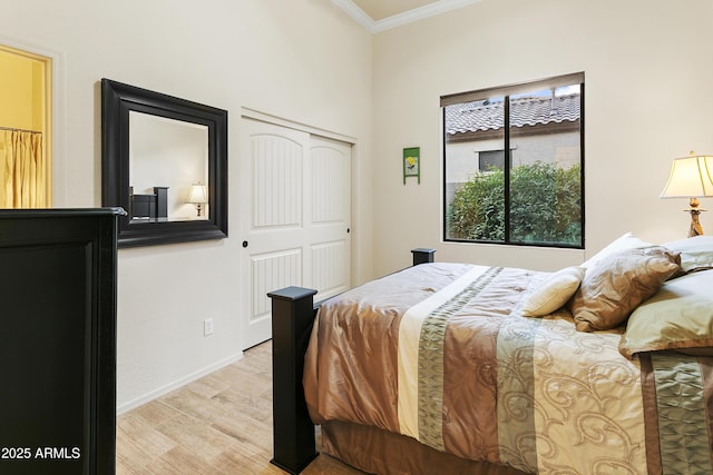 bedroom featuring crown molding, a closet, and light hardwood / wood-style flooring