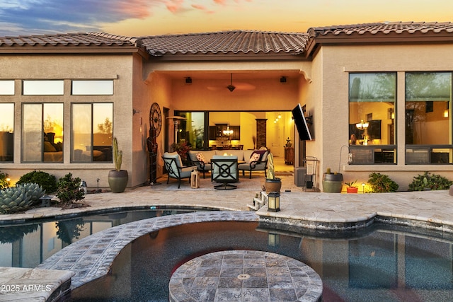 pool at dusk featuring outdoor lounge area and a patio