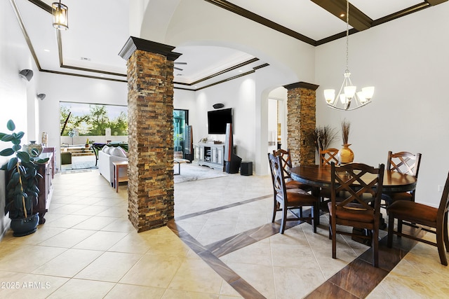 dining area featuring a notable chandelier, ornate columns, crown molding, and a towering ceiling