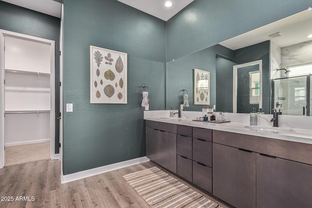 bathroom featuring wood-type flooring, vanity, and a shower with shower door