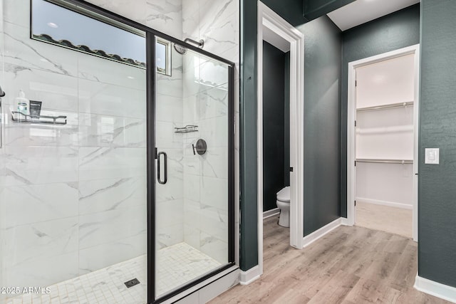 bathroom with hardwood / wood-style flooring, toilet, and walk in shower