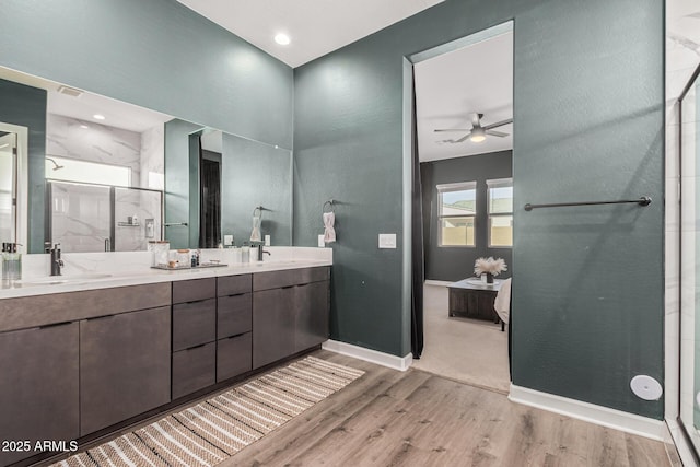 bathroom featuring hardwood / wood-style flooring, vanity, ceiling fan, and walk in shower