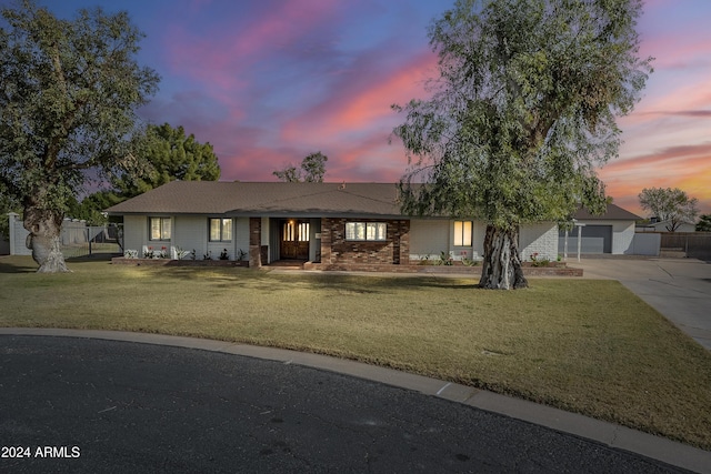 ranch-style house featuring a lawn and a garage