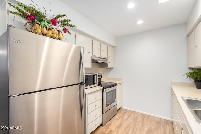 kitchen with stainless steel appliances, sink, white cabinetry, and light hardwood / wood-style flooring