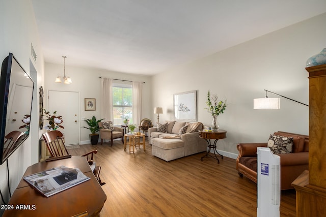 living room featuring an inviting chandelier and hardwood / wood-style flooring