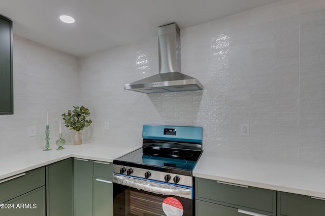 kitchen featuring tasteful backsplash, electric stove, green cabinets, and wall chimney range hood