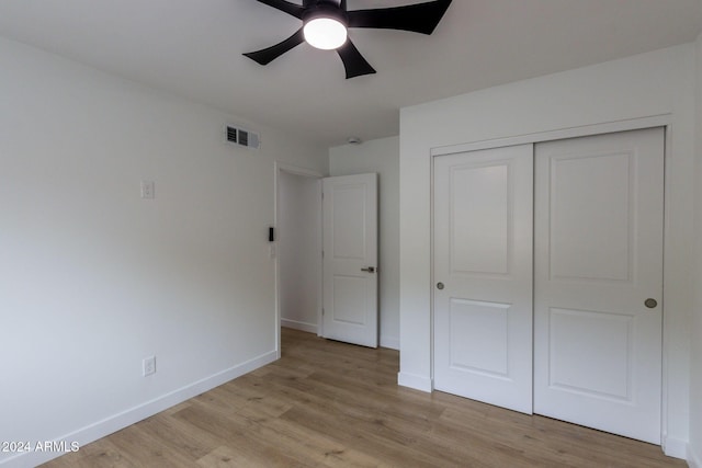 unfurnished bedroom featuring ceiling fan, light wood-type flooring, and a closet