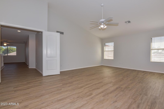 unfurnished room with wood-type flooring, a wealth of natural light, ceiling fan, and high vaulted ceiling