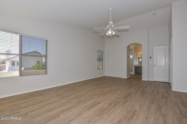 spare room with hardwood / wood-style flooring, ceiling fan, and a high ceiling