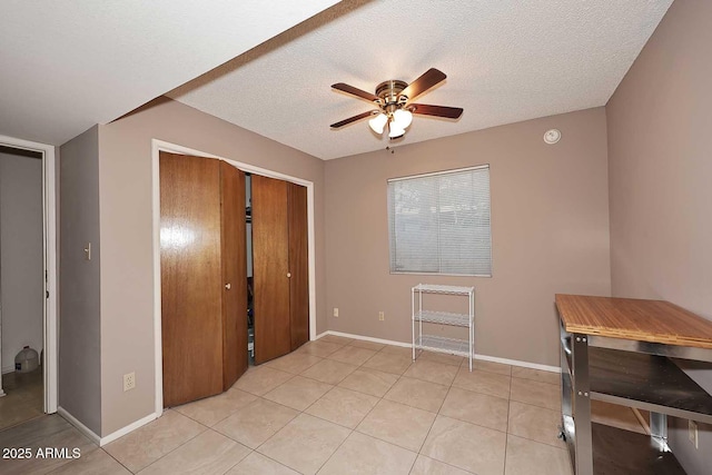 foyer featuring a textured ceiling, ceiling fan, and light tile patterned flooring