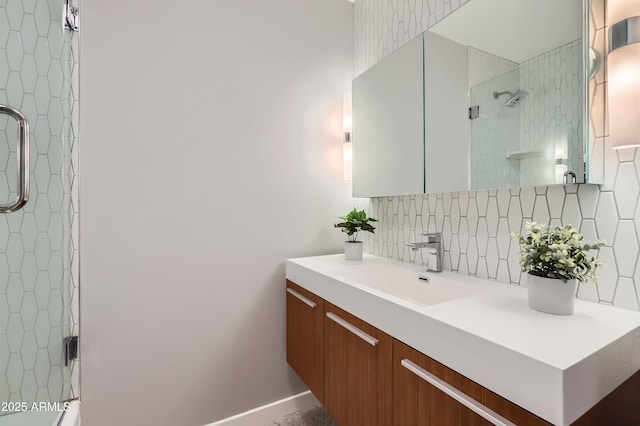 full bath featuring vanity, tasteful backsplash, and a tile shower