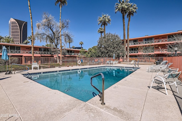 pool with a patio area and fence