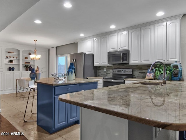 kitchen featuring a center island, hanging light fixtures, stainless steel appliances, a breakfast bar area, and white cabinets