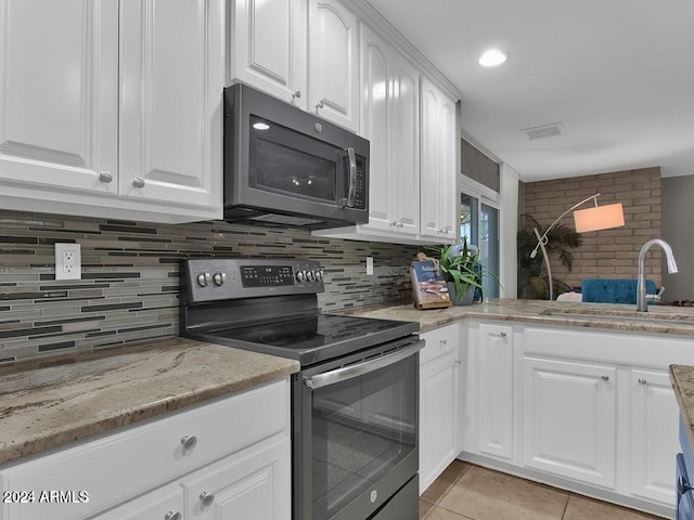 kitchen featuring backsplash, white cabinets, sink, light stone counters, and stainless steel appliances