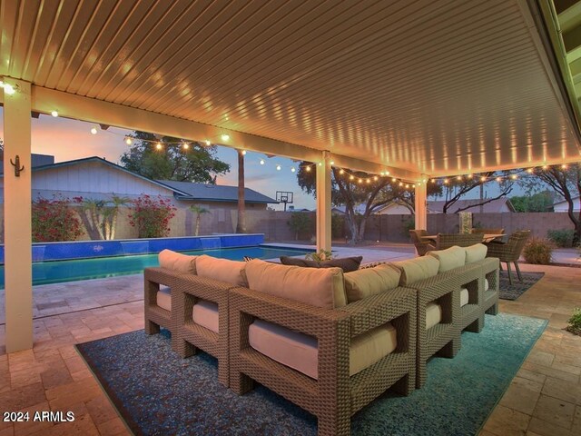 patio terrace at dusk featuring a fenced in pool and an outdoor hangout area