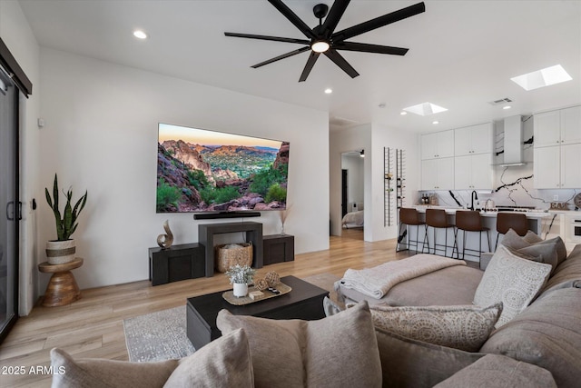 16533 E Dale Ln, Scottsdale, AZ 85262 - living room featuring a skylight, light wood finished floors, recessed lighting, and a ceiling fan