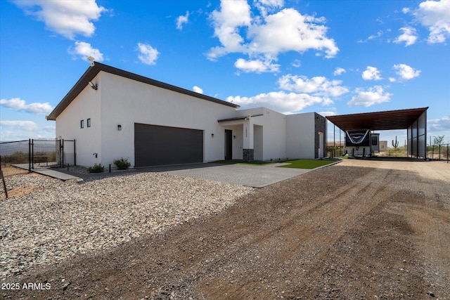 16533 E Dale Ln, Scottsdale, AZ 85262 - contemporary house featuring dirt driveway, stucco siding, a gate, and a garage