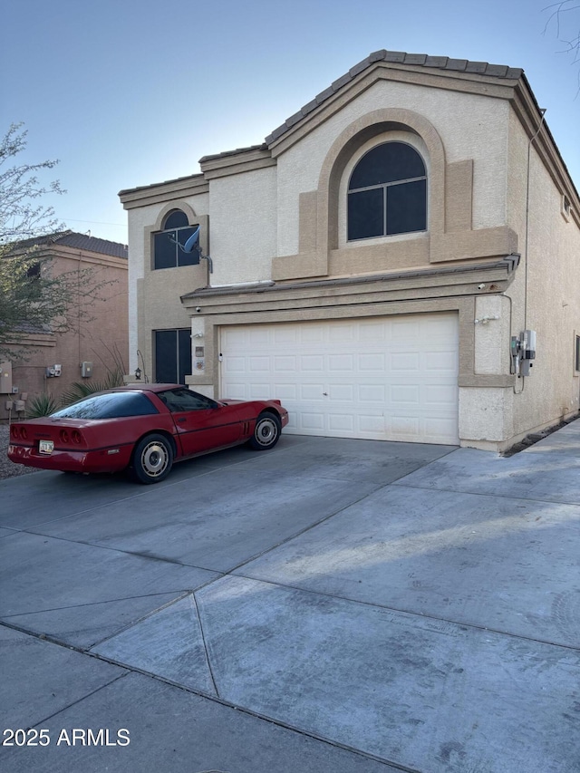 view of front of home with driveway, a garage, and stucco siding