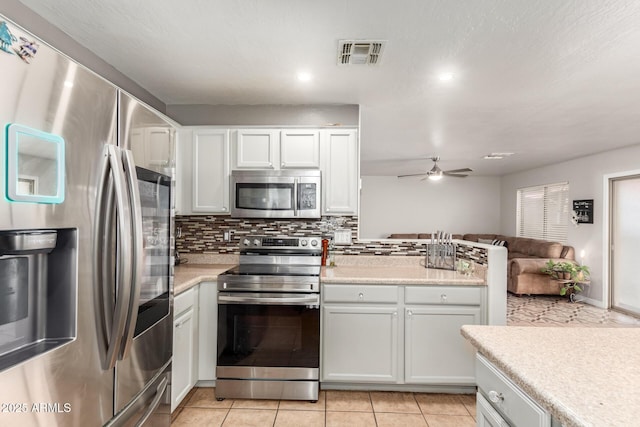 kitchen featuring appliances with stainless steel finishes, light countertops, open floor plan, and visible vents