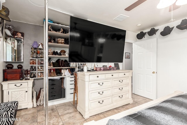 walk in closet with ceiling fan, visible vents, and light tile patterned flooring