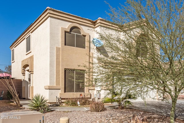 exterior space featuring a tile roof and stucco siding