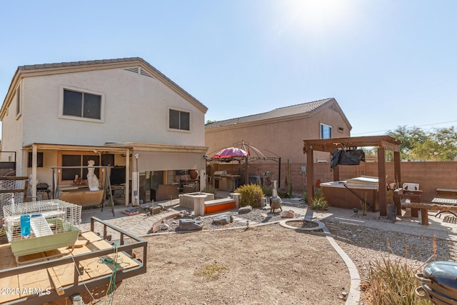 rear view of house with a patio area, a hot tub, stucco siding, and a gazebo