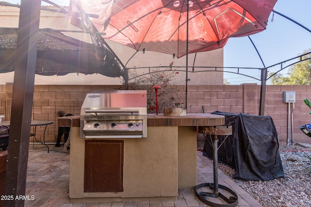 view of patio / terrace featuring a grill, outdoor dry bar, area for grilling, and fence