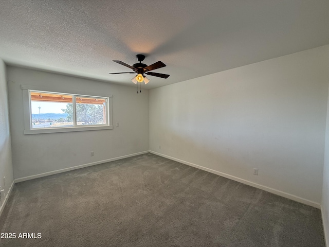 empty room with baseboards, dark carpet, and a textured ceiling