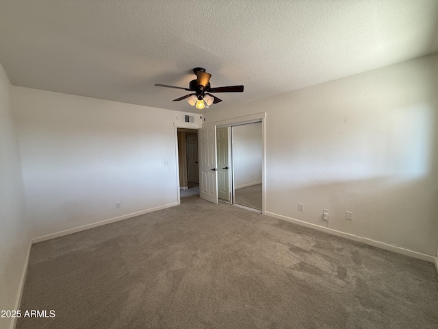 spare room featuring baseboards, visible vents, a textured ceiling, and carpet