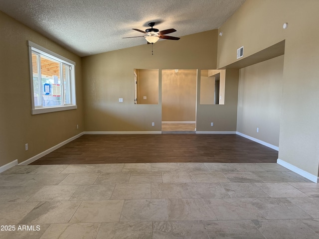 spare room featuring visible vents, ceiling fan, baseboards, vaulted ceiling, and a textured ceiling