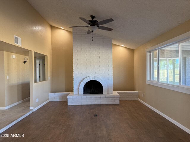 unfurnished living room featuring visible vents, a fireplace, dark wood-type flooring, and vaulted ceiling
