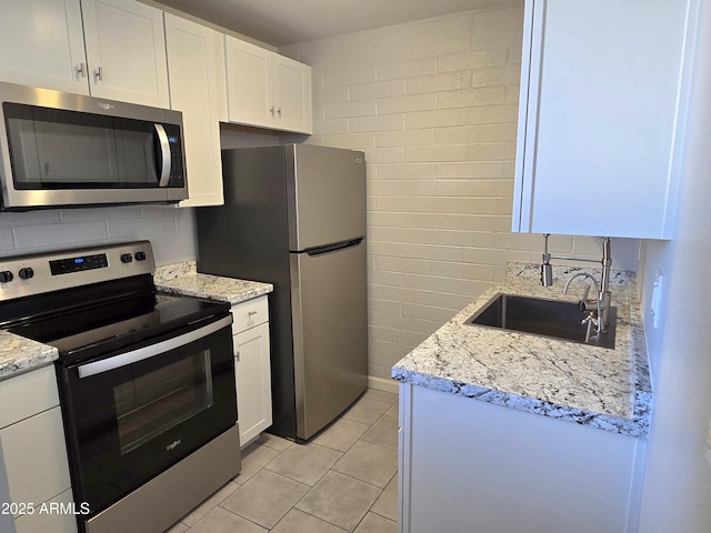 815 N Hayden Rd Unit A205, Scottsdale, AZ 85257 - kitchen with stainless steel appliances, white cabinets, light tile patterned floors, and light stone countertops