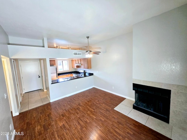 unfurnished living room with light hardwood / wood-style floors, ceiling fan, and a fireplace